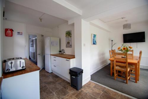una cucina con tavolo, frigorifero e tavolo di Granby Grove Townhouse - Sleeps 8- 4 Bedrooms a Southampton
