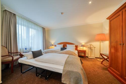 a hotel room with two beds and a window at Parkhotel Am Glienberg by NP in Zinnowitz