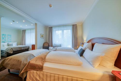 a bedroom with two beds with white pillows at Parkhotel Am Glienberg by NP in Zinnowitz