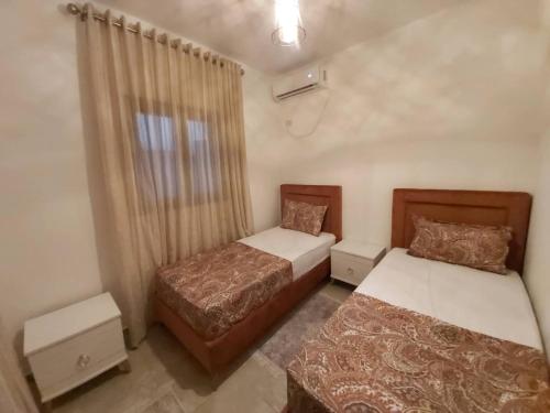 ein Schlafzimmer mit zwei Betten und einem Fenster in der Unterkunft Villa TAGUERMES in Taguermess
