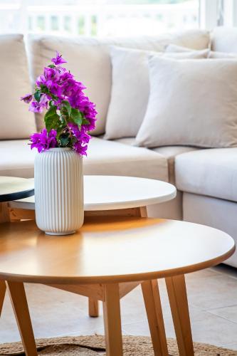 a vase with purple flowers sitting on a coffee table at Aurora Skopelos in Skopelos Town
