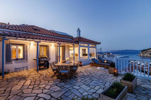 a patio with a table and chairs on a house at Aurora Skopelos in Skopelos Town