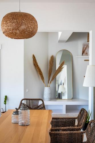 a dining room with a table and chairs and a mirror at Aurora Skopelos in Skopelos Town