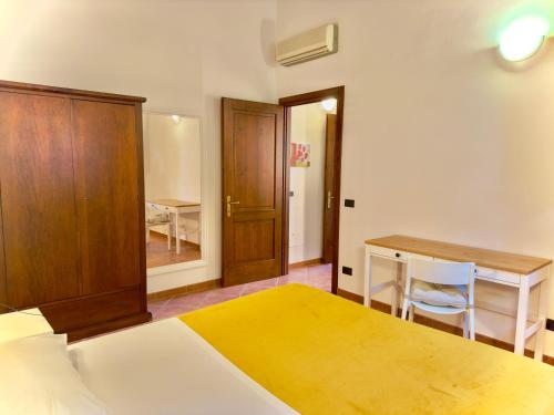 a bedroom with a bed and a desk and a table at Pianferrari Agriturismo in Maremma in Alberese
