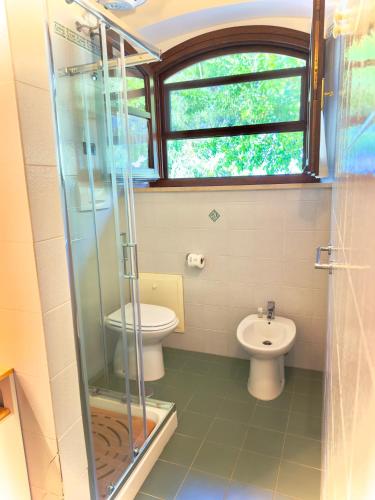a bathroom with a toilet and a glass shower at Pianferrari Agriturismo in Maremma in Alberese