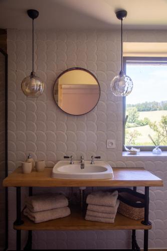 une salle de bain avec un lavabo et un miroir dans l'établissement Les Tables de La Rousse, à La Fouillade