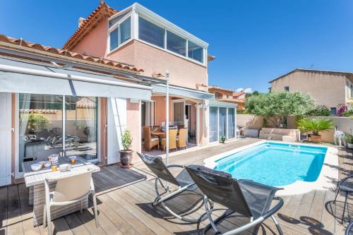 une terrasse avec une piscine et des chaises ainsi qu'une maison dans l'établissement La Perle Bandolaise - Welkeys, à Bandol