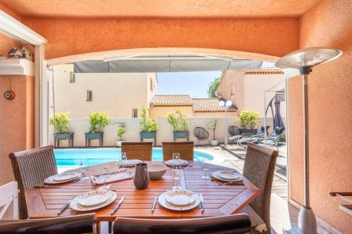 une table avec des chaises et un parasol sur une terrasse dans l'établissement La Perle Bandolaise - Welkeys, à Bandol