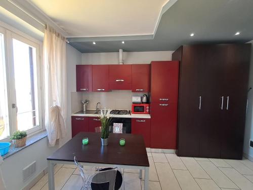 a kitchen with red cabinets and a table in it at Appartamento Valentina in Cremona