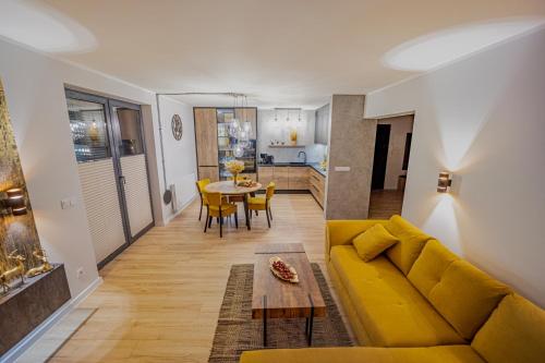 a living room with a yellow couch and a table at Apartament w Cieplicach Platinium in Jelenia Góra