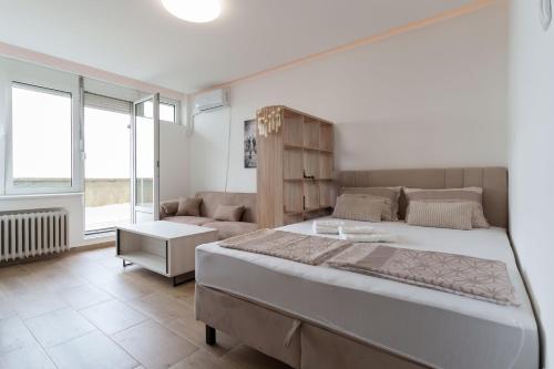 a bedroom with a large bed and a couch at MaKi apartment in Belgrade