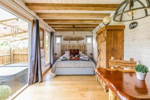 a bedroom with a bed and a table at La Roulotte de la Trigalle in Valognes