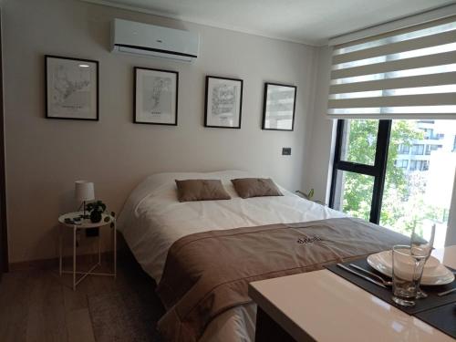 a bedroom with a large bed and a window at ELDEPTO Padre Mariano Apart Hotel in Santiago