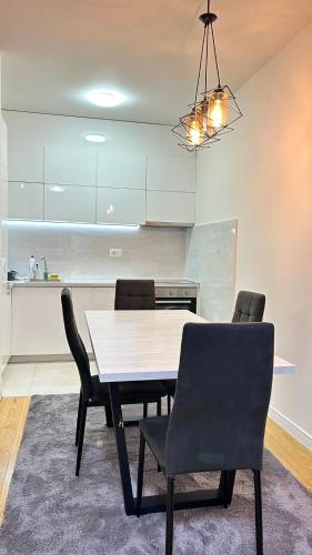 uma mesa de jantar e cadeiras numa cozinha em Comfort Central Point apartment em Podgorica