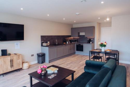 a living room with a couch and a table and a kitchen at Raleigh Waterside apartment - The Barbican, Plymouth in Plymouth