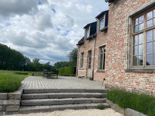 a brick building with a bench in front of it at Huis Potaerde, vakantiewoning op boerderij - luxe landhuis nabij Brussel in Merchtem