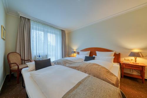 a hotel room with two beds and a window at Parkhotel Am Glienberg by NP in Zinnowitz