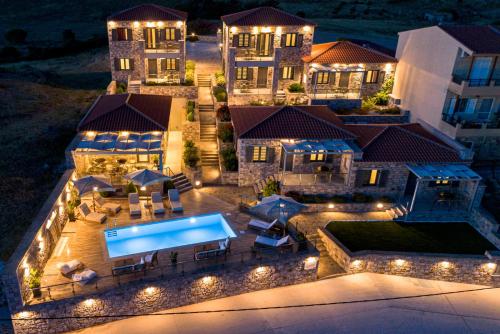 z góry widok na dom w nocy z basenem w obiekcie Lithoessa Luxury Apartments w mieście Agios Ioannis Kaspaka