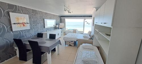 a living room with a table and a dining room at Modern studio with beautiful sea view - 9th floor in Blankenberge