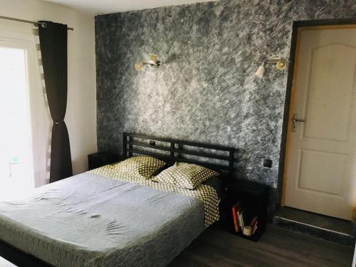 - une chambre avec un lit et un mur en béton dans l'établissement Villa au calme dans le Luberon avec piscine, à Cheval-Blanc