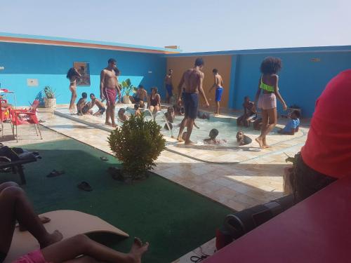 a group of people playing in a swimming pool at Residencial Oliveira in Porto Novo