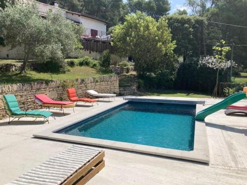 une piscine avec deux chaises et une piscine dans l'établissement Villa au calme dans le Luberon avec piscine, à Cheval-Blanc