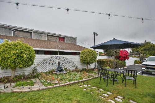 a table and chairs and an umbrella in a yard at Best Western Surf City in Huntington Beach
