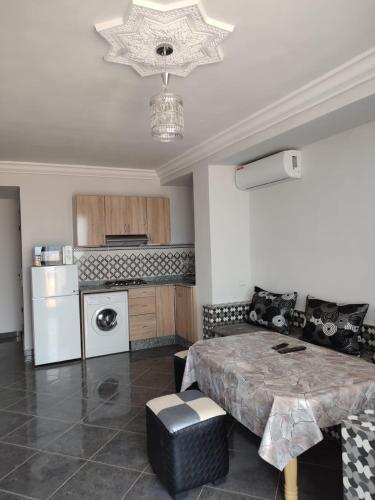 a living room with a table and a kitchen at Résidence Les Deux Mules in Ahfir