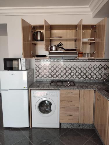 a kitchen with a dishwasher and a washer at Résidence Les Deux Mules in Ahfir
