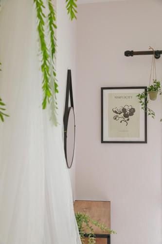 a white wall with a picture and a mirror on it at 'Anassa Residence in Xanthi