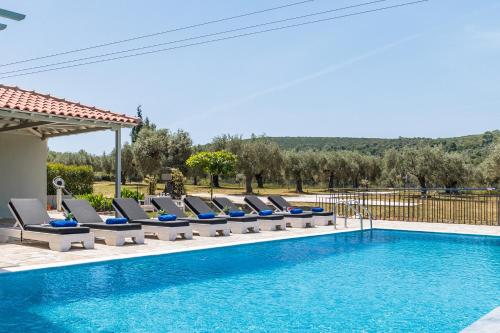a swimming pool with lounge chairs next to a swimming pool at Villa Aelia by Kardous in Alikias