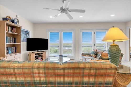 a living room with a couch and a flat screen tv at Prime Time in Caswell Beach
