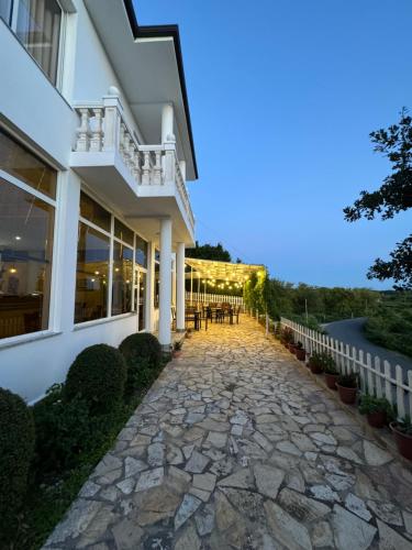 a house with a stone walkway in front of it at Vila Horizont in Baks-Rrjoll