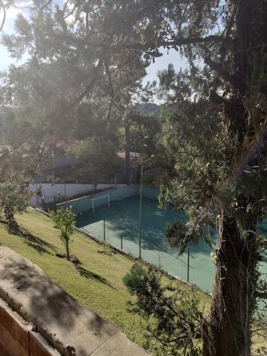 a swimming pool in a yard with a tree at Chácara, próx a SP, com WI-FI e uma vista incrível in São Roque