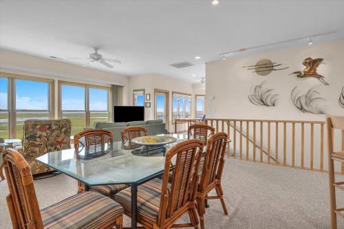 a dining room with a glass table and chairs at Prime Time in Caswell Beach