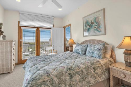 a bedroom with a large bed and a balcony at Prime Time in Caswell Beach