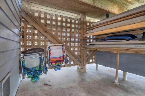 a room with a wooden attic with a table and luggage at Prime Time in Caswell Beach