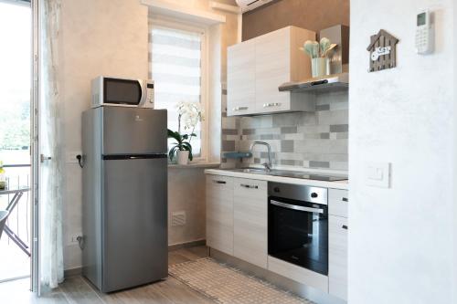 a kitchen with a refrigerator and a sink at Appartamento Rayan Alba Wine Retreat nelle Langhe in Alba
