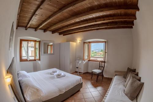 1 dormitorio con 1 cama y 1 sofá en Appartamenti Villa Giulia, en Bellagio