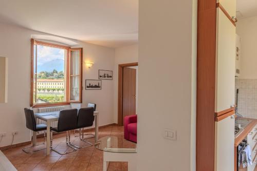 sala de estar con mesa, sillas y ventana en Appartamenti Villa Giulia, en Bellagio