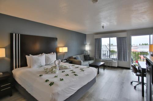 una habitación de hotel con una cama grande con flores. en Best Western Surf City en Huntington Beach