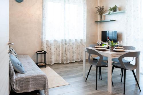 a dining room with a white table and chairs at Appartamento Rayan Alba Wine Retreat nelle Langhe in Alba