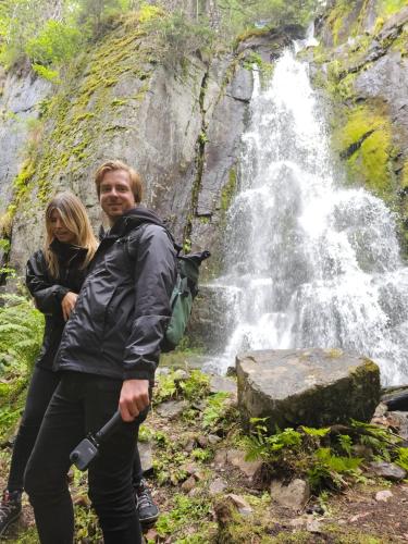 a man and woman standing in front of a waterfall at Villa Fregn in Ljørdal