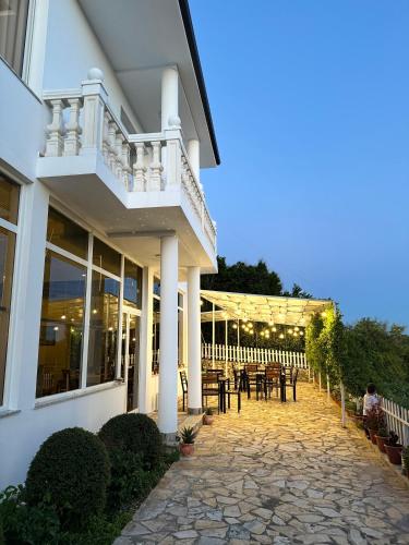 a building with a patio with tables and chairs at Vila Horizont in Baks-Rrjoll