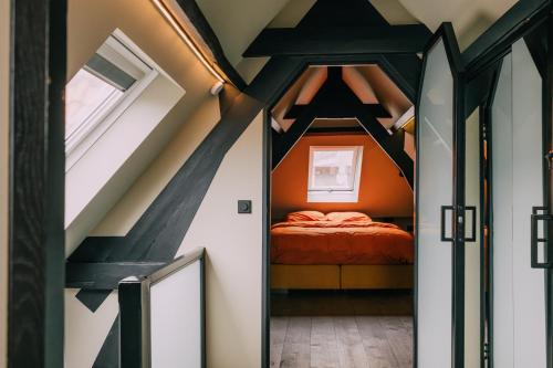 a bedroom with an orange bed in a attic at TheBridge29 boutique apartment in Breda