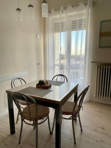 a table and chairs in a room with a window at Appartamento Casa Fontana Asti in Asti