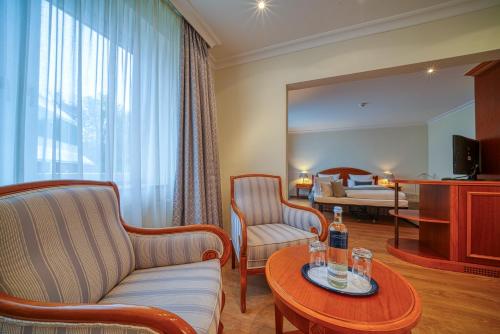 a living room with a couch and a table at Parkhotel Am Glienberg by NP in Zinnowitz