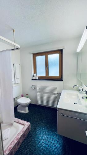 ein Badezimmer mit einem WC, einer Badewanne und einem Waschbecken in der Unterkunft Casa Terza - CharmingStay in Flumserberg