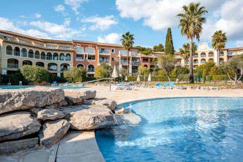 une piscine en face d'un grand bâtiment dans l'établissement Résidence Les Rivages des Issambres - maeva Home - Appartement 2 pièces 4 personnes - Prestige MAE-8321, aux Issambres