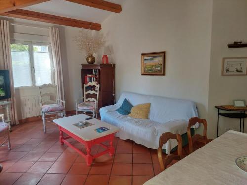 a living room with a couch and a table at Charmante maison avec jardin in Manosque